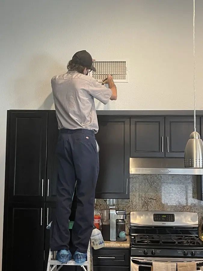 Technician inspecting an air vent during HVAC service in Saugerties